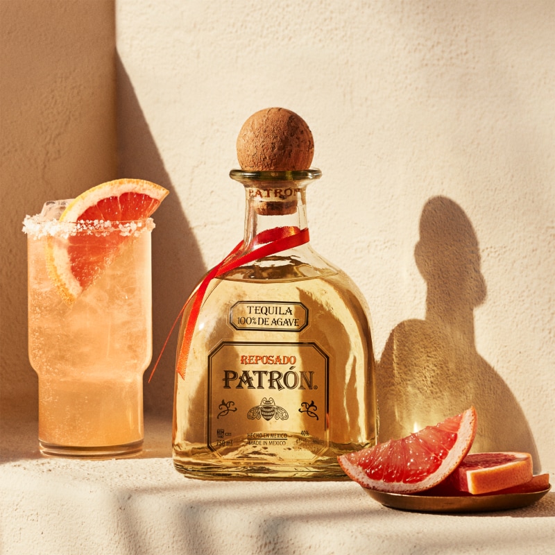 Bottle of Patrón Reposado and a paloma cocktail.